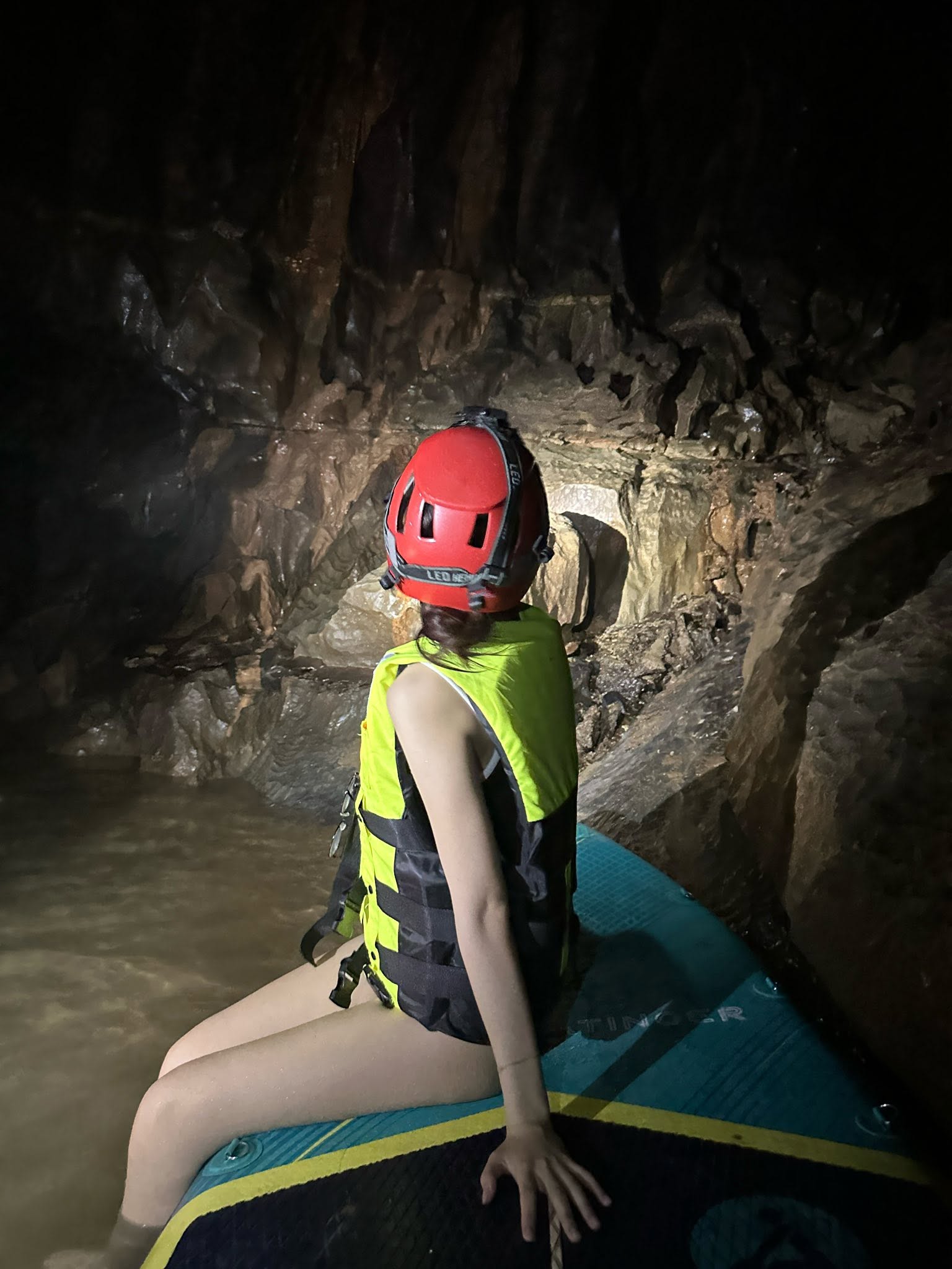 A visitor wearing a helmet explores Hang E on a SUP board