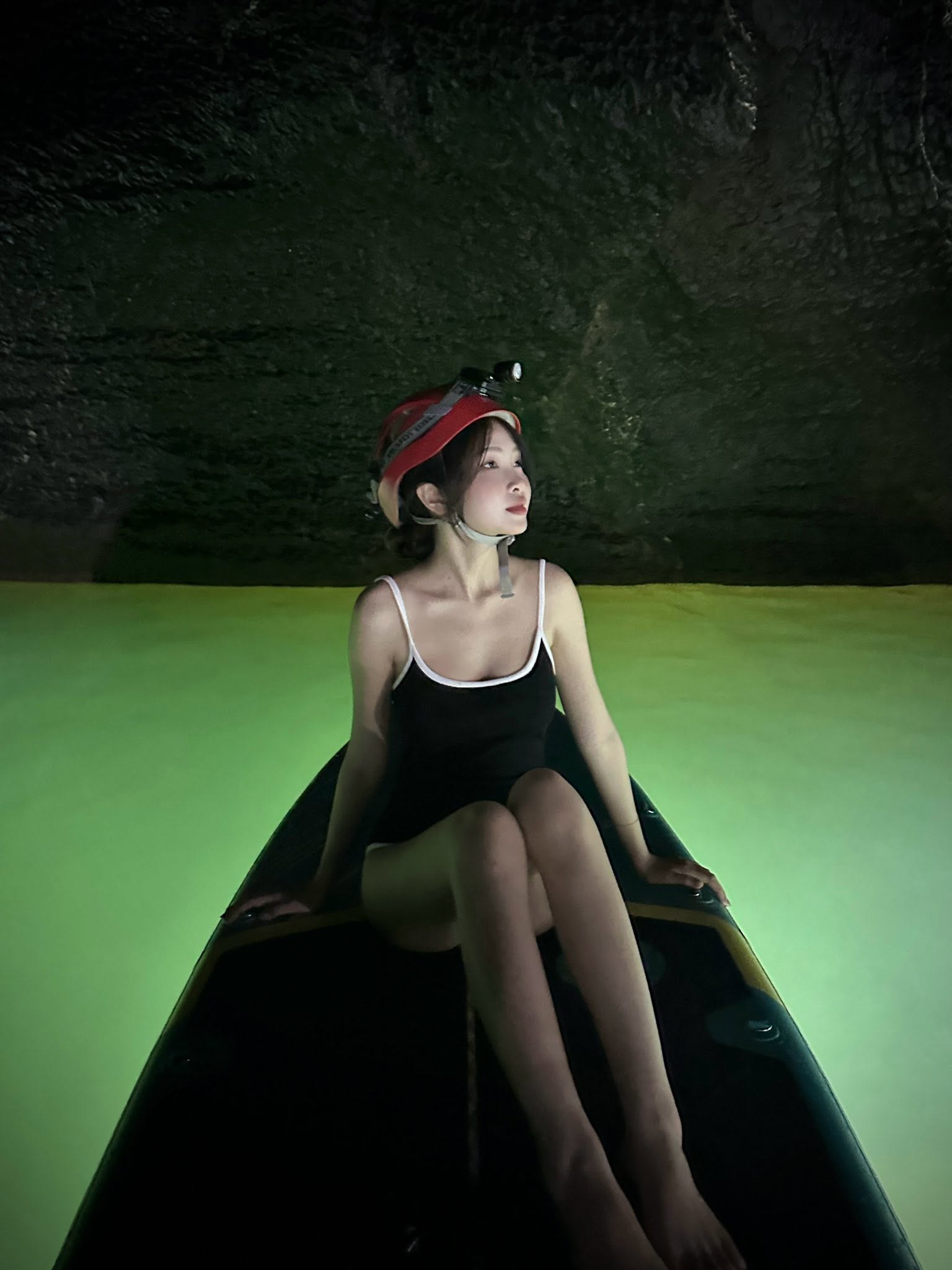 A visitor paddles across the green water inside Hang E