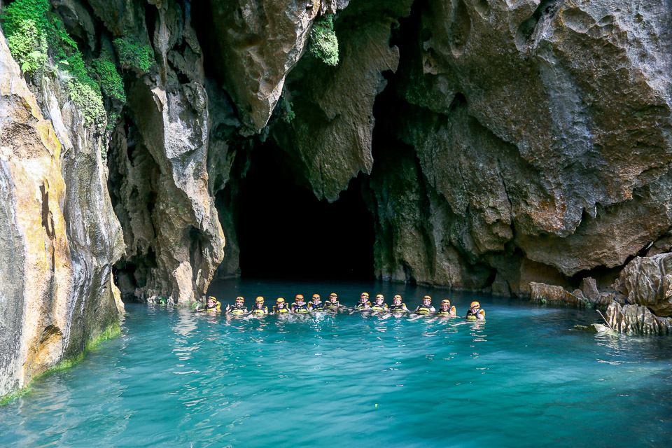 Travelers swimming in an underground pool on a Jungle Boss tour